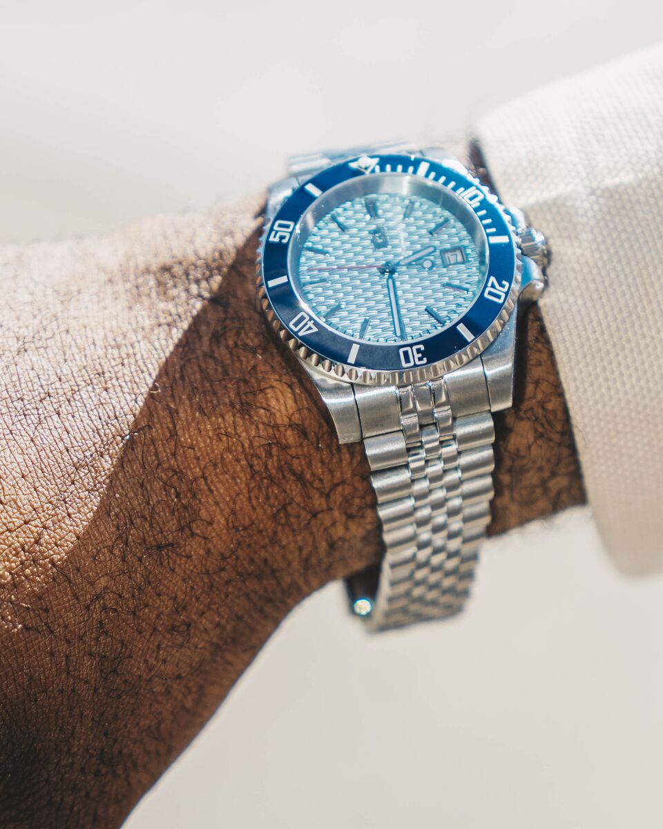 A Mr. Eatwell diver worn on a wrist in sunlight, with the bezel numerals and bracelet links sharp.